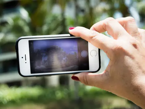 A hand holding a phone sideways to take a photograph