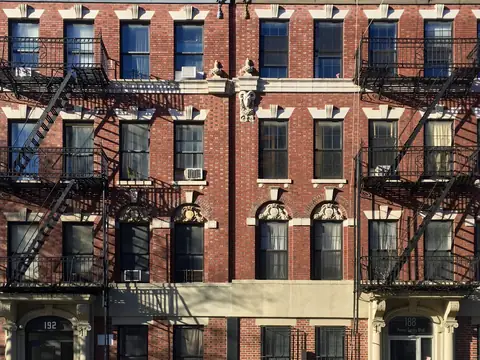 Red brick apartment buildings with fire escapes on Marcus Garvey Boulevard in Bedford-Stuyvesant, Brooklyn