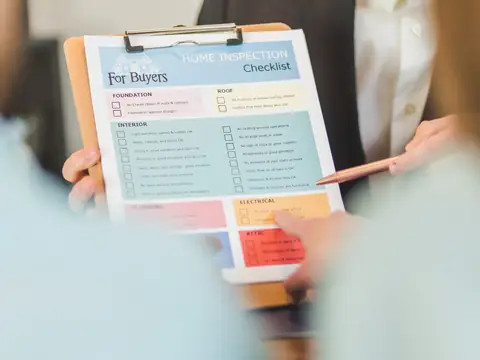 A home inspection checklist on a clipboard, a pen ready to tick it off