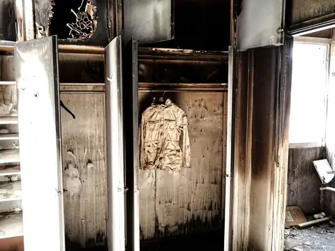 Soot-streaked closet doors and walls in a room after a fire