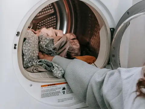 Laundry being loaded into a front-loading washing machine